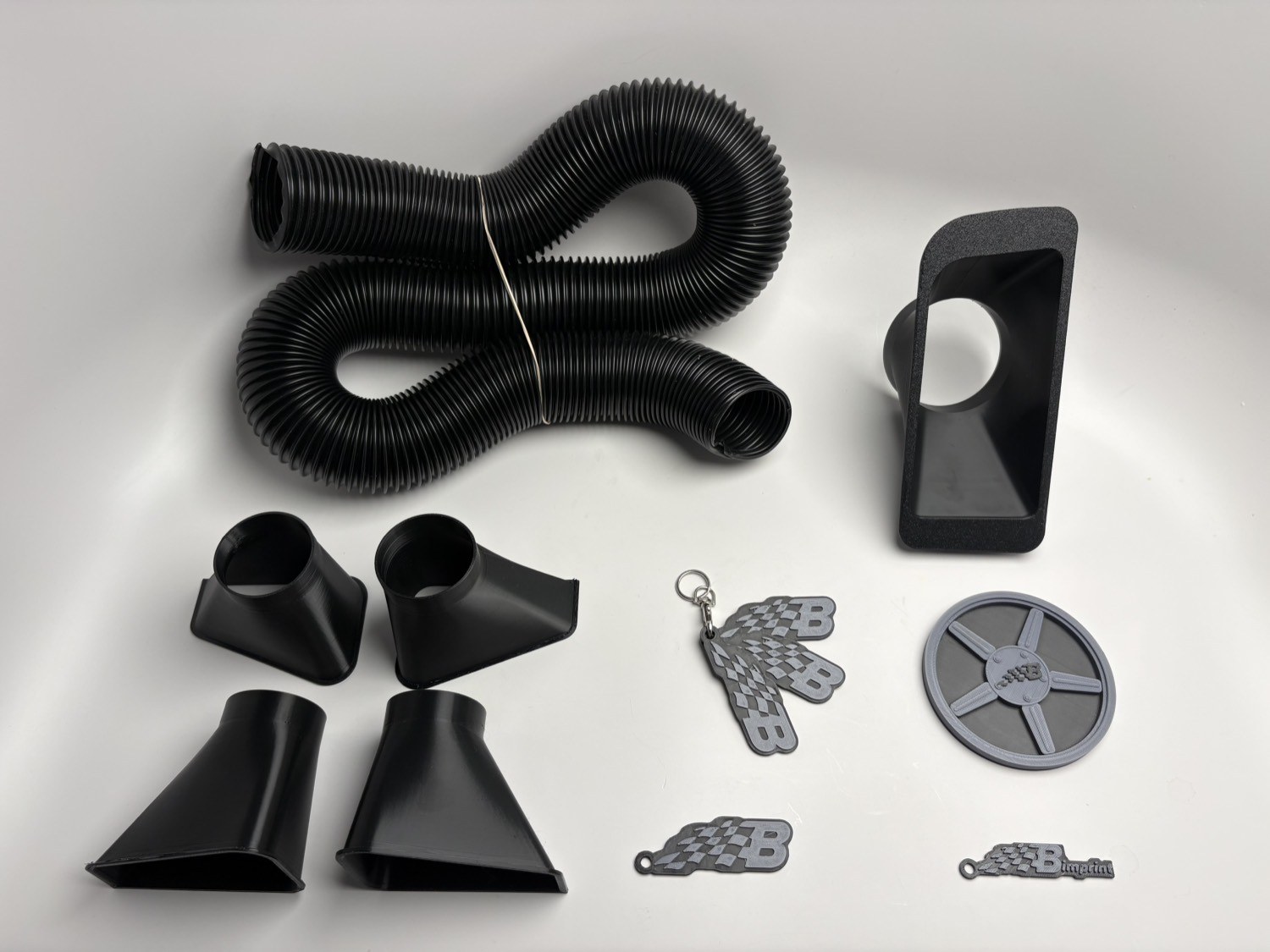 Bimprint lineup: M3 brake hoses and ducts, the E36 fog duct, both keychains, and the coaster
